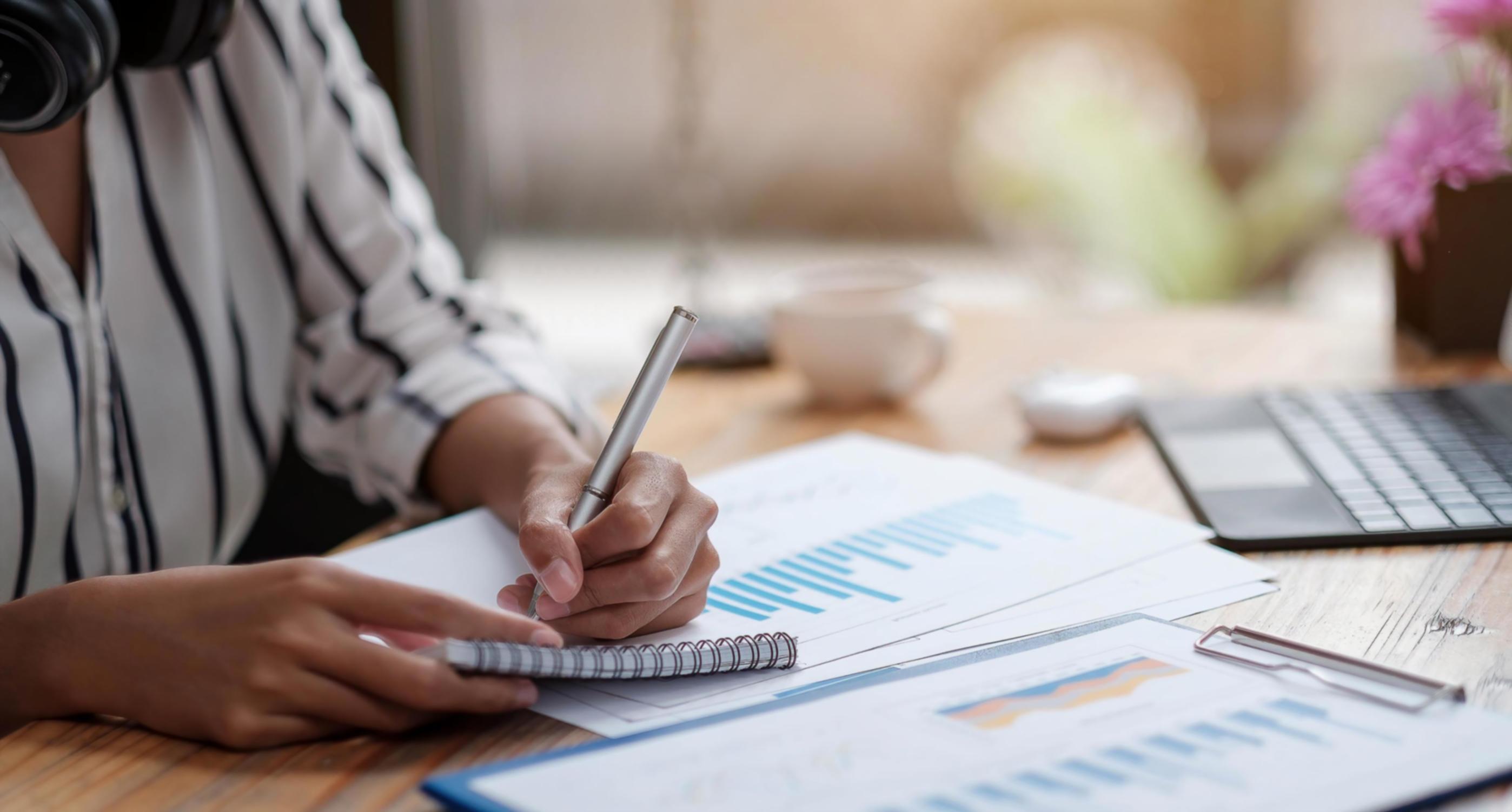Business professional reviewing financial documents and strategic planning materials in modern office setting